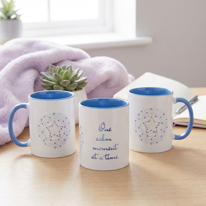 Three mugs with blue interior and exterior on a wooden surface, one with a motivational quote.