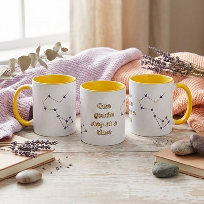 Three mugs with yellow interior and constellation designs on a wooden surface with lavender and stones.